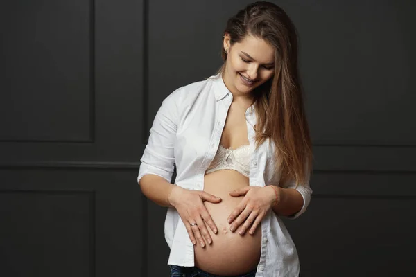 Gorgeous ung gravid kvinna röra försiktigt med händerna hennes mage, skicka kärlek till hennes ofödda barn — Stockfoto