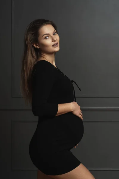 Porträtt vacker ung gravid kvinna röra försiktigt med händerna hennes mage, hon väntar ett nytt liv — Stockfoto