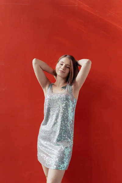 Jovencita alegre posando frente a una pared roja —  Fotos de Stock