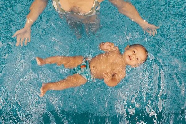 Madre e hijo pequeño divirtiéndose en una piscina — Foto de Stock