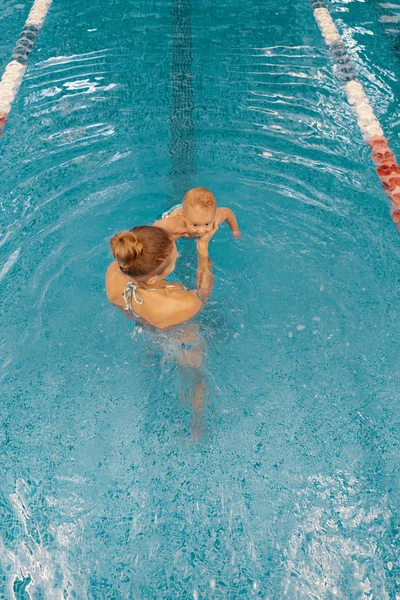 Mãe e filho pequeno se divertindo em uma piscina — Fotografia de Stock