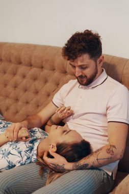 Oturma odasındaki kanepede sevgili bir çift.