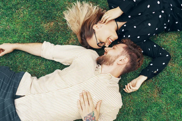 Casal apaixonado deitado na grama — Fotografia de Stock