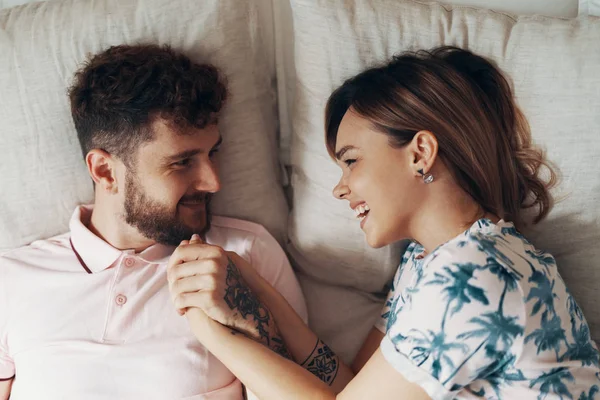 Pareja enamorada se abraza en la cama —  Fotos de Stock