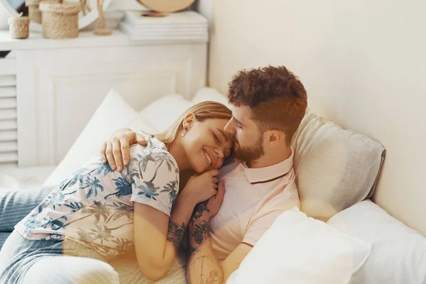 Coppia innamorata sta abbracciando sul letto — Foto Stock