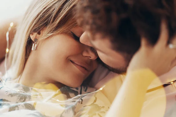 Casal apaixonado é abraçar na cama — Fotografia de Stock