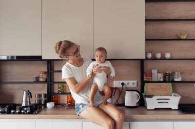 Mutfakta bebeği olan genç bir anne.