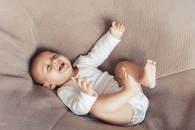 Çocuk kocaman bir yastığın üzerinde yatıyor.