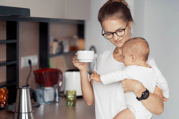 Jeune mère avec bébé dans la cuisine — Photo