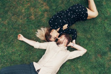 Aşık çift kendi evlerinin arka bahçesinde çimenlerin üzerinde yatıyor. Yukarıdan görüntüle