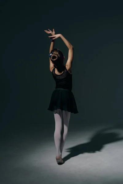 아름다운 발레리나가 가벼운 그림자의 어두운 배경에서 — 스톡 사진