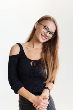 Beyaz arka planda gözlüklü, gülümseyen zarif bir kadın. Siyah deri etekli, yetişkin, güzel bir iş kadını. Boşluğu kopyala