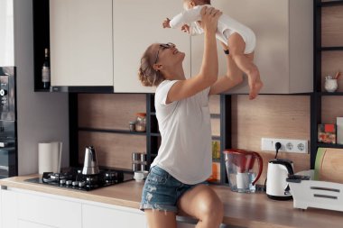 Mutfakta bebeği olan genç bir anne.