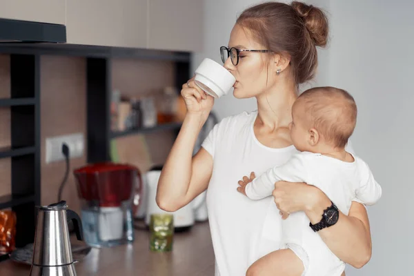 Jeune mère avec bébé dans la cuisine — Photo