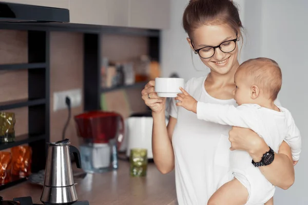 Jeune mère avec bébé dans la cuisine — Photo