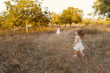 Güzel kız kardeşler doğada tatil yaparken oyun oynuyorlar.