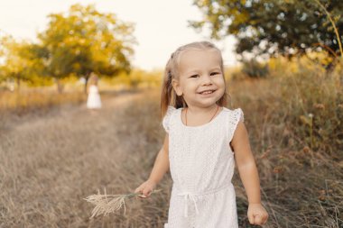 Güzel kız kardeşler doğada tatil yaparken oyun oynuyorlar.