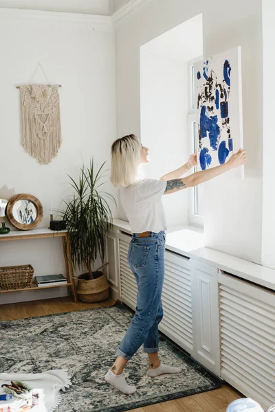Jonge vrouw plaatst abstracte verf op de muur — Stockfoto