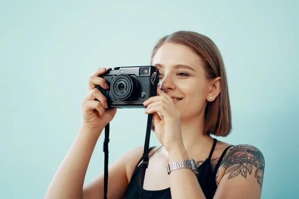 Junge Fotografin fotografiert auf blauem Hintergrund — Stockfoto