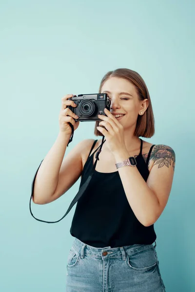 Junge Fotografin fotografiert auf blauem Hintergrund — Stockfoto