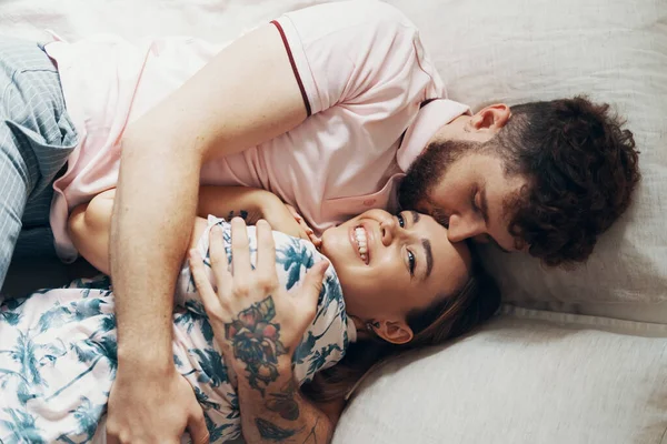 Zamilovaní manželé se objímali na posteli — Stock fotografie