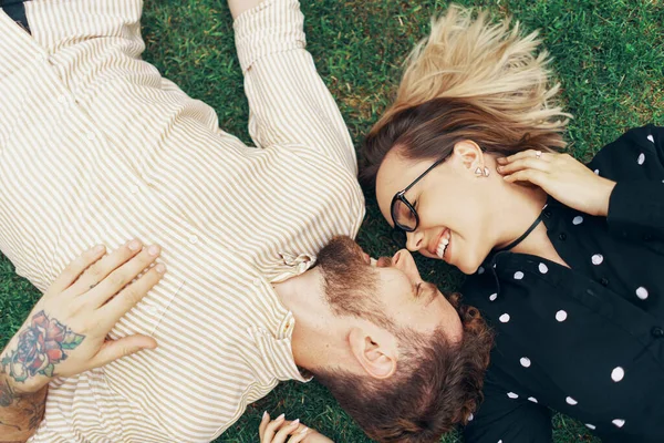 Pár v lásce ležící na trávě — Stock fotografie