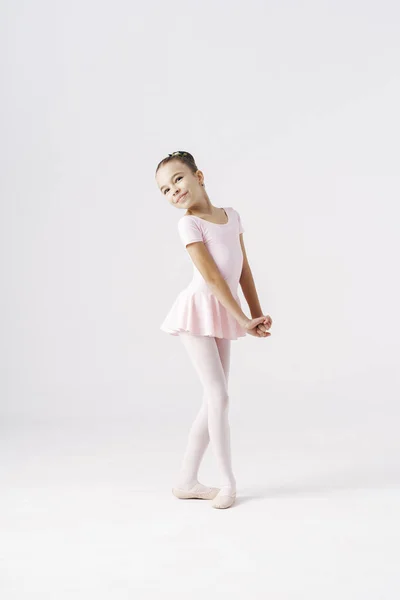 Чарівна заздалегідь балерина танцює на білому тлі — стокове фото