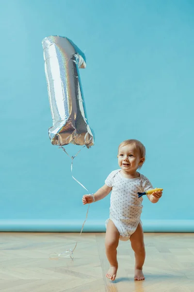 Anak berjalan dengan satu tahun balon pada latar belakang biru — Stok Foto