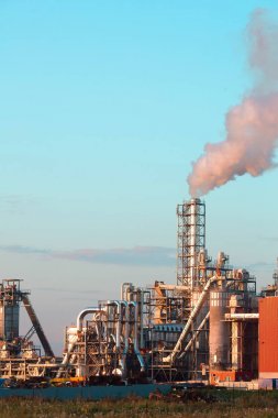 Bir kanalda bir mavi gökyüzü arka plan dışarı duman egzoz ile endüstriyel tesis