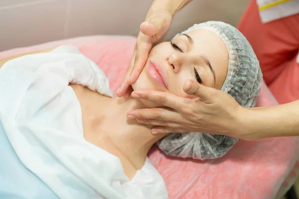 Hermosa joven en un masaje facial — Foto de Stock