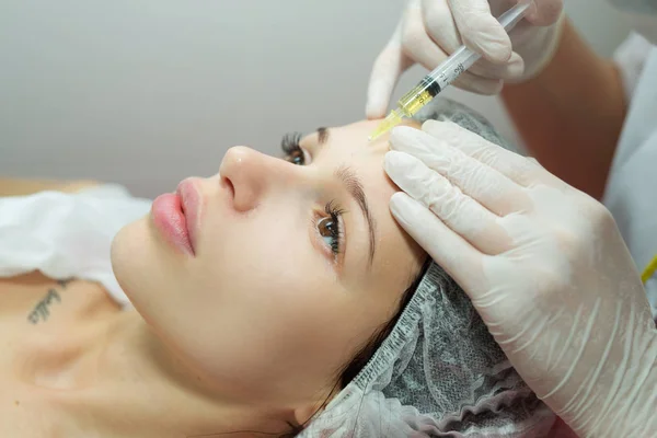 Beautiful young girl of European appearance on the procedure of injecting — Stock Photo, Image