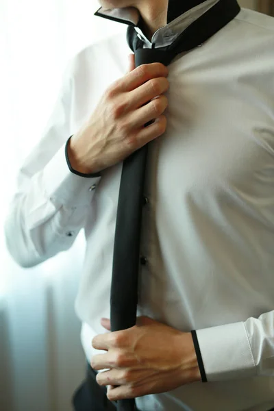 Een man aan te passen zijn zwarte stropdas — Stockfoto