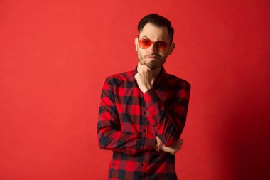 kırmızı gözlük takan Kareli gömlekli şık genç adam