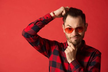 kırmızı gözlük takan Kareli gömlekli şık genç adam