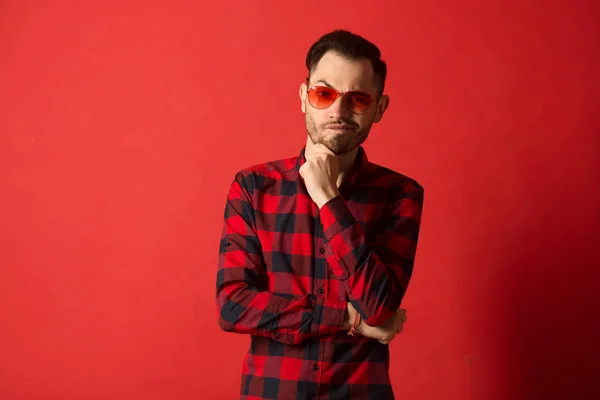 stylish young guy in checkered shirt wearing red glasses