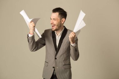 bir takım belgeler ile iş yerinde yorgun bir tıraşsız yüzü olan genç bir adam