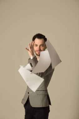 bir takım belgeler ile iş yerinde yorgun bir tıraşsız yüzü olan genç bir adam