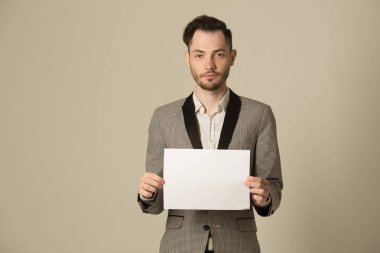 genç bir adam ile bir takım elbise ile beyaz kağıt bir tıraşsız yüzü