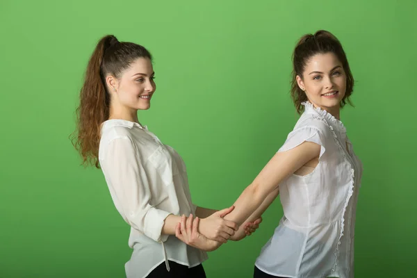 两个美丽的积极的女孩与快乐的情绪在绿色背景 — 图库照片
