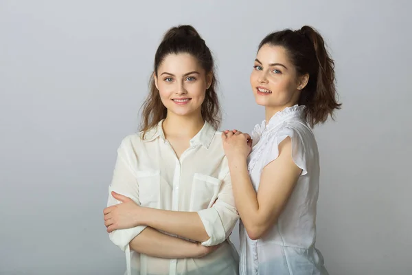 Zwei Schöne Lächelnde Schwestern Zwillinge Weißen Blusen Auf Hellem Hintergrund — Stockfoto