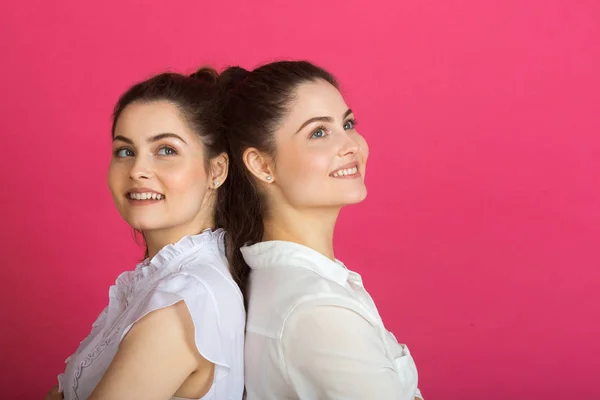 Dvě Krásné Mladé Sestry Dvě Dívky Úsměvem Růžovém Pozadí — Stock fotografie