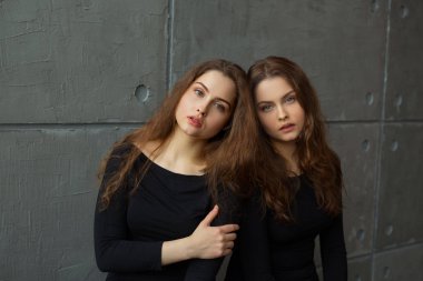 akan ile ikiz kardeşler iki güzel genç kız portre saç iç gri duvara karşı