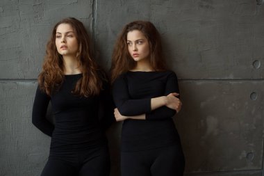 akan ile ikiz kardeşler iki güzel genç kız portre saç iç gri duvara karşı