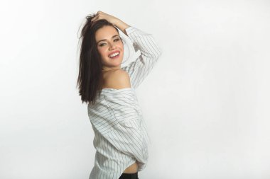 Beyaz bir arka plan üzerinde siyah saçlı güzel genç kız gülümseyerek