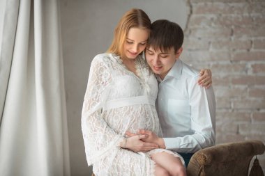 birbirlerinin kollarında güzel genç çift karı koca hamile içinde beyaz dantel elbise