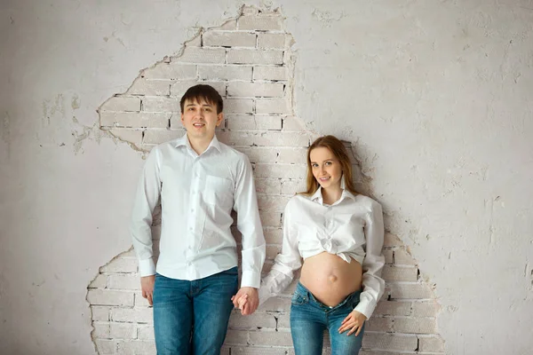 Belo Marido Mulher Grávida Jeans Camisa Branca Perto Parede Branca — Fotografia de Stock