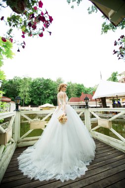 bir tren ile lüks bir elbise düğün buket Park ile güzel bir genç gelin portresi