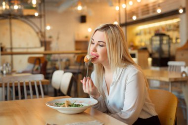 bir salata yemek bir restoranda oturan güzel genç kız