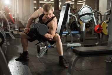 yakışıklı genç eğitim salonunda dumbbells ile
