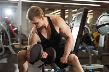 yakışıklı genç eğitim salonunda dumbbells ile